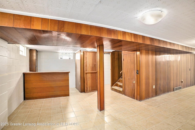 4810 Cherryland Dr, Lansing, MI 48910 - below grade area featuring concrete block wall, wooden walls, and light tile patterned floors