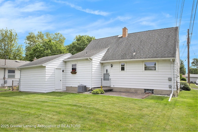 4810 Cherryland Dr, Lansing, MI 48910 - rear view of property featuring central AC unit, a chimney, and a shingled roof