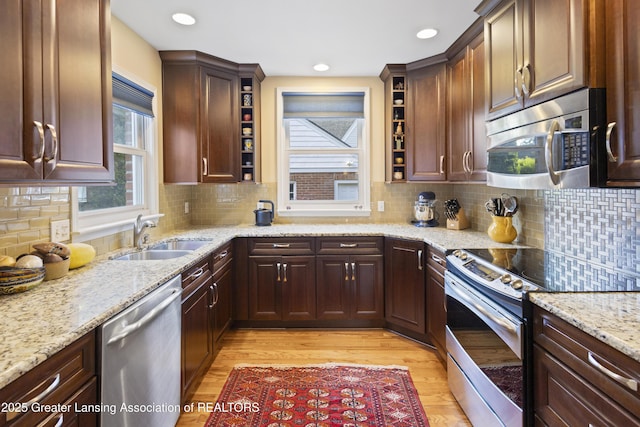 438 Bailey St, East Lansing, MI 48823 - kitchen with appliances with stainless steel finishes, a sink, open shelves, light wood-type flooring, and recessed lighting