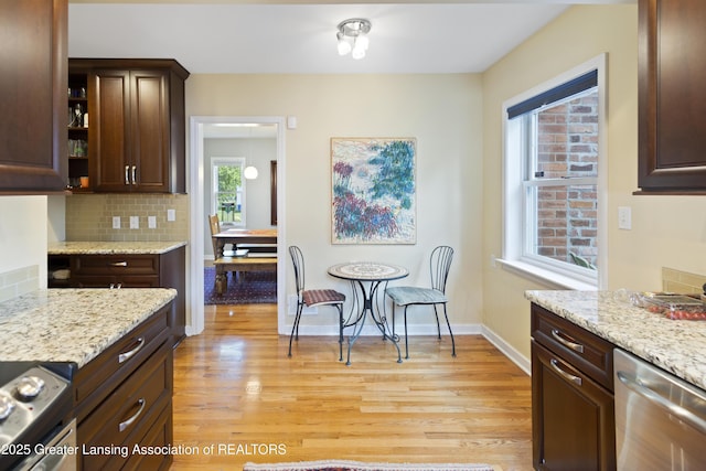438 Bailey St, East Lansing, MI 48823 - kitchen with stainless steel appliances, light wood-style floors, dark brown cabinets, decorative backsplash, and light stone countertops