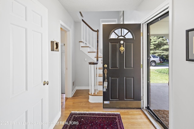 438 Bailey St, East Lansing, MI 48823 - foyer entrance featuring light wood-style floors, stairway, and baseboards