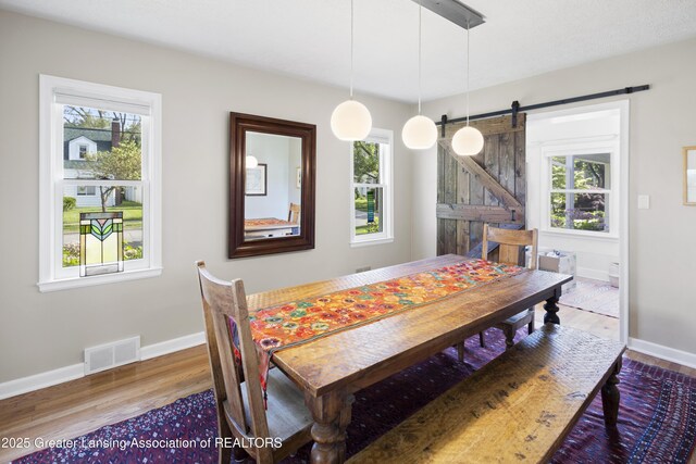 438 Bailey St, East Lansing, MI 48823 - dining area with a barn door, wood finished floors, and healthy amount of natural light