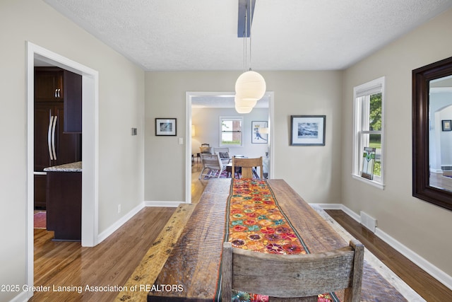 438 Bailey St, East Lansing, MI 48823 - dining room featuring wood finished floors, baseboards, and a textured ceiling