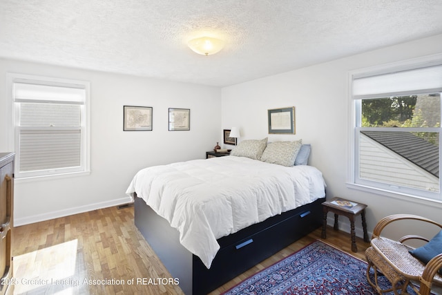 438 Bailey St, East Lansing, MI 48823 - bedroom with a textured ceiling, wood finished floors, and baseboards