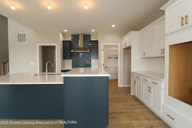 615 Magenta Ct, Haslett, MI 48840 - kitchen featuring wall chimney range hood, backsplash, a sink, light wood-type flooring, and recessed lighting