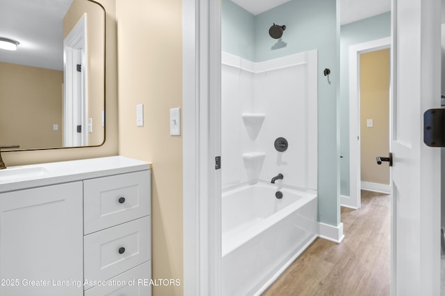 1221 W Saginaw St, Lansing, MI 48915 - full bathroom with wood finished floors, shower / bath combination, vanity, and baseboards