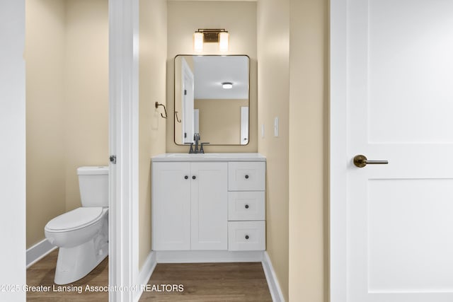 1221 W Saginaw St, Lansing, MI 48915 - bathroom with toilet, vanity, wood finished floors, and baseboards