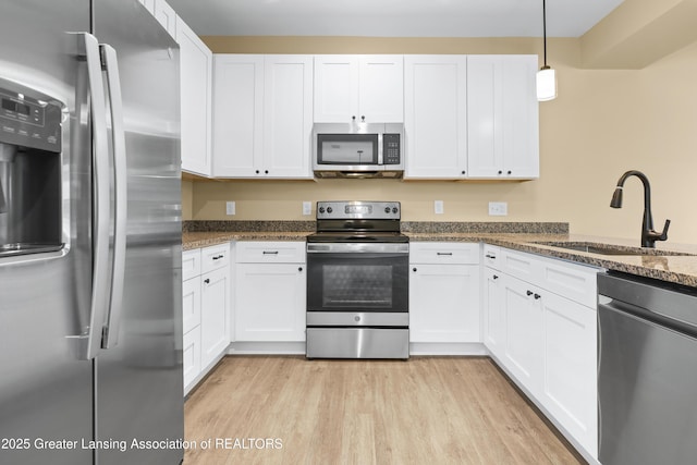 1221 W Saginaw St, Lansing, MI 48915 - kitchen featuring stainless steel appliances, a sink, white cabinets, and dark stone counters