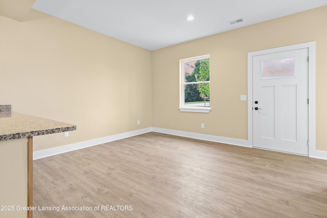 1221 W Saginaw St, Lansing, MI 48915 - unfurnished living room with baseboards, light wood-type flooring, and recessed lighting