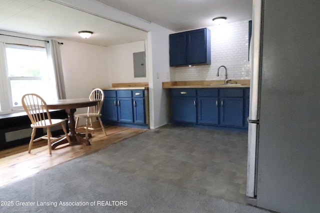 5413 S Waverly Rd, Lansing, MI 48911 - kitchen with blue cabinets, freestanding refrigerator, electric panel, a sink, and tasteful backsplash