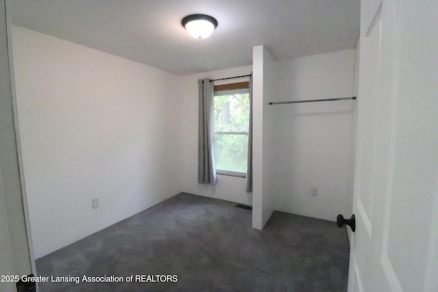 5413 S Waverly Rd, Lansing, MI 48911 - unfurnished bedroom featuring dark carpet