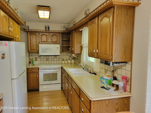 718 W Shepherd St, Charlotte, MI 48813 - kitchen with white appliances, a sink, brown cabinets, and a textured ceiling
