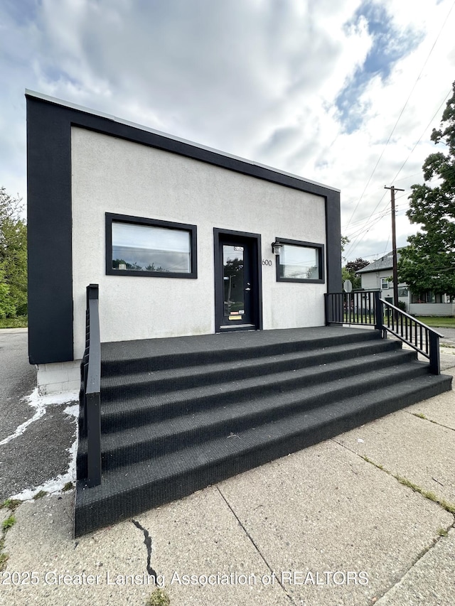 600 E Cavanaugh Rd, Lansing, MI 48910 - view of home's exterior featuring stucco siding
