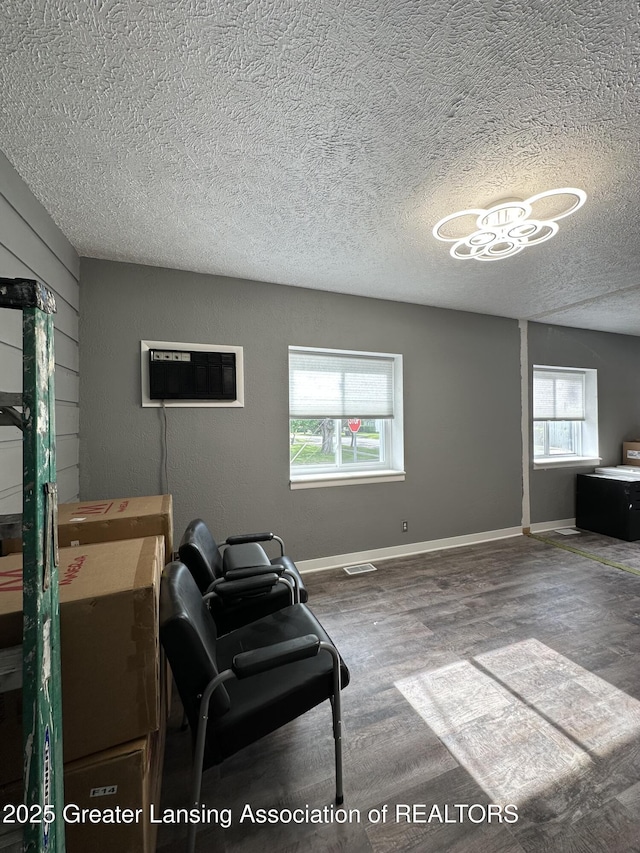600 E Cavanaugh Rd, Lansing, MI 48910 - living area with a textured ceiling, a wall mounted AC, and wood finished floors