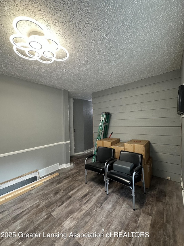 600 E Cavanaugh Rd, Lansing, MI 48910 - living area with wood finished floors, a textured ceiling, and baseboards