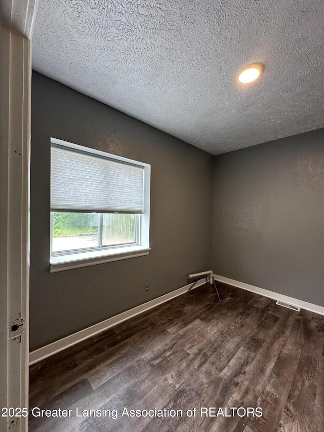 600 E Cavanaugh Rd, Lansing, MI 48910 - unfurnished room with wood finished floors, a textured ceiling, and baseboards