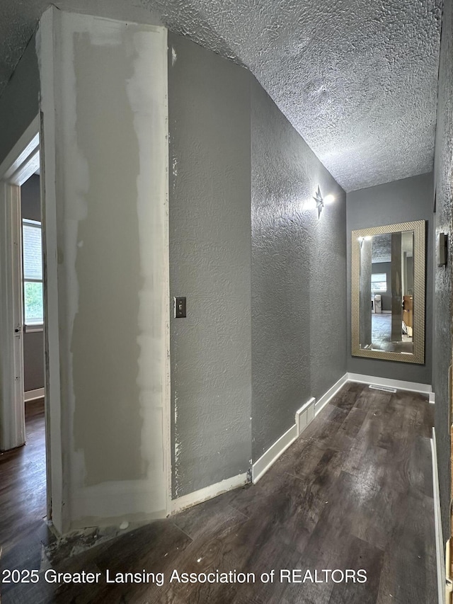 600 E Cavanaugh Rd, Lansing, MI 48910 - hallway featuring a textured wall, wood finished floors, a textured ceiling, and baseboards