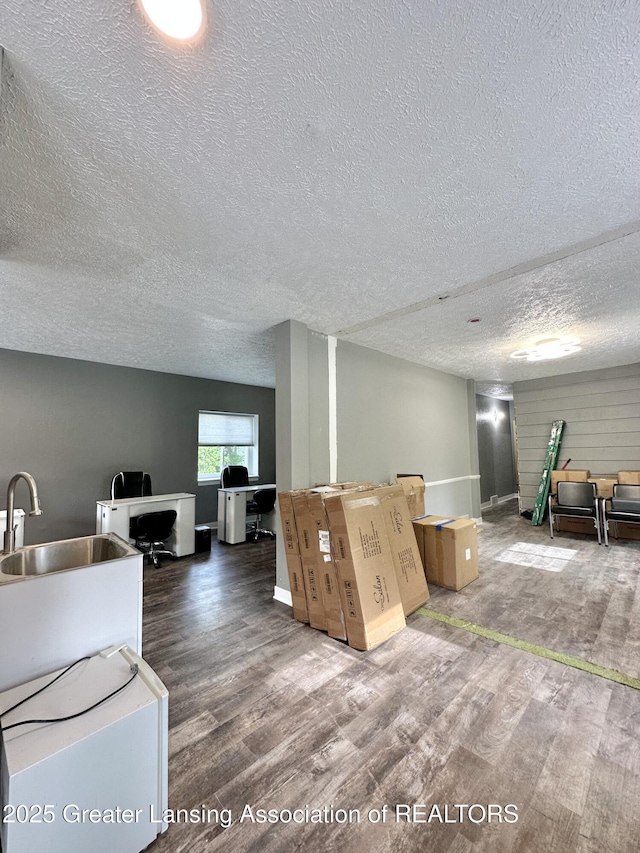 600 E Cavanaugh Rd, Lansing, MI 48910 - kitchen with wood finished floors, a textured ceiling, a sink, and baseboards