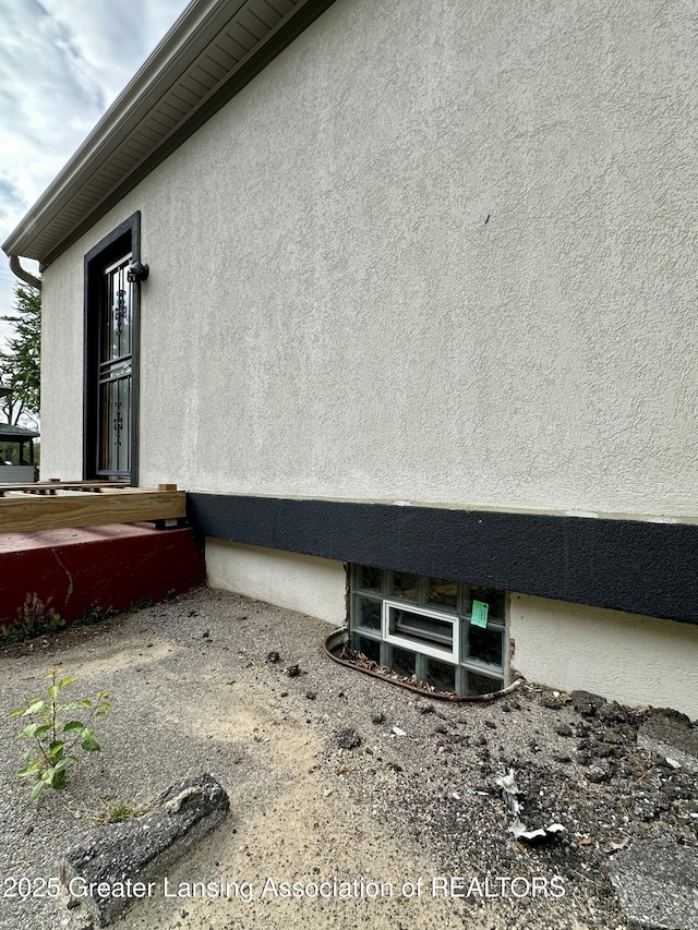 600 E Cavanaugh Rd, Lansing, MI 48910 - view of side of home featuring stucco siding