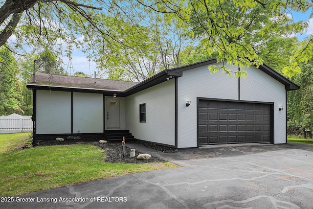 6420 Clise Rd, Bath, MI 48808 - mid-century modern home featuring entry steps, an attached garage, and asphalt driveway