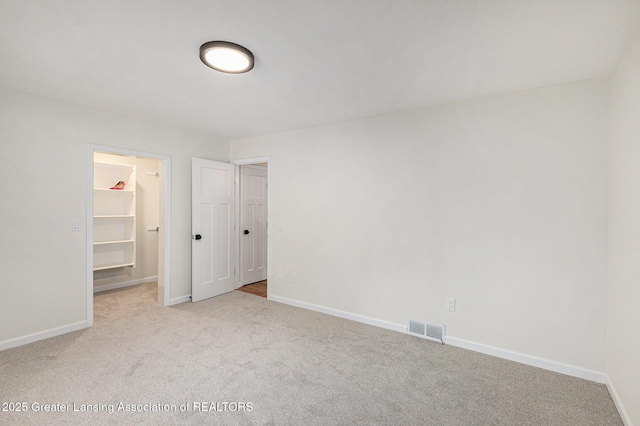 6420 Clise Rd, Bath, MI 48808 - unfurnished bedroom with carpet flooring, a walk in closet, baseboards, and a closet