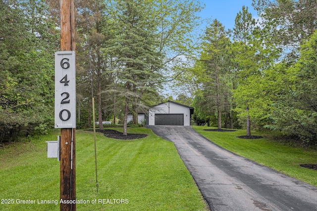 6420 Clise Rd, Bath, MI 48808 - view of front of home featuring a front yard, a garage, an outdoor structure, and asphalt driveway