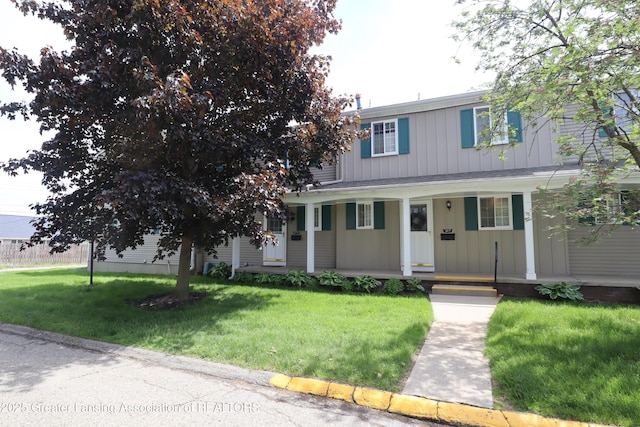 1615 Peppertree Ln, Lansing, MI 48912 - view of front facade with covered porch, a front lawn, and board and batten siding