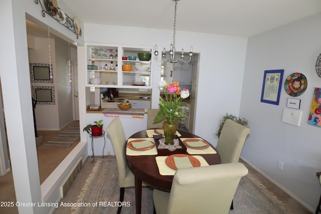 1615 Peppertree Ln, Lansing, MI 48912 - dining room featuring a chandelier, carpet flooring, and baseboards