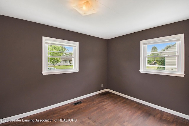 4512 Alpha St, Lansing, MI 48910 - spare room featuring baseboards and dark wood-style flooring