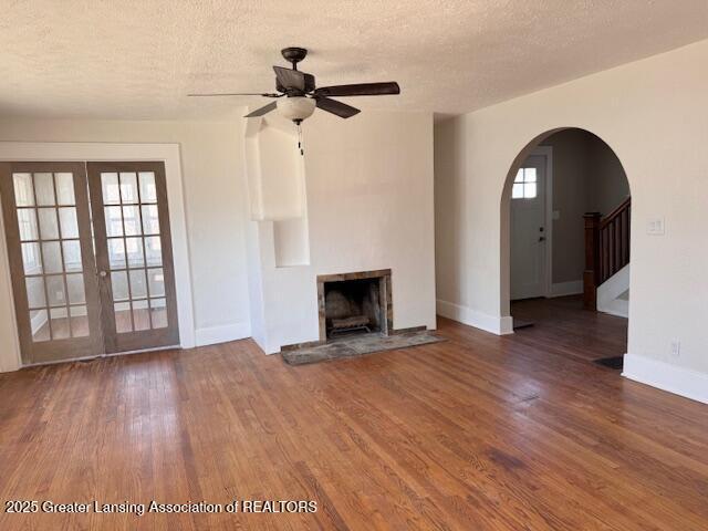 1305 W Hillsdale St, Lansing, MI 48915 - unfurnished living room featuring wood finished floors, ceiling fan, a textured ceiling, and plenty of natural light