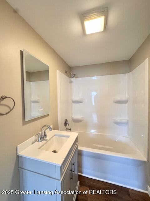 1305 W Hillsdale St, Lansing, MI 48915 - bathroom with vanity, shower / bath combination, and wood finished floors
