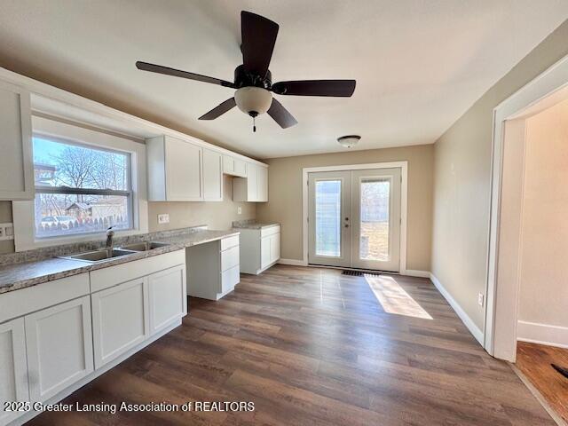 1305 W Hillsdale St, Lansing, MI 48915 - kitchen featuring a sink, dark wood-type flooring, french doors, and white cabinetry