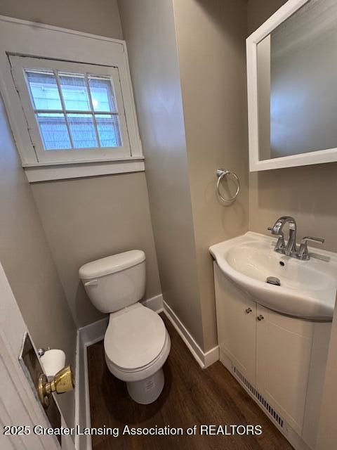 1305 W Hillsdale St, Lansing, MI 48915 - bathroom featuring vanity, toilet, wood finished floors, and baseboards