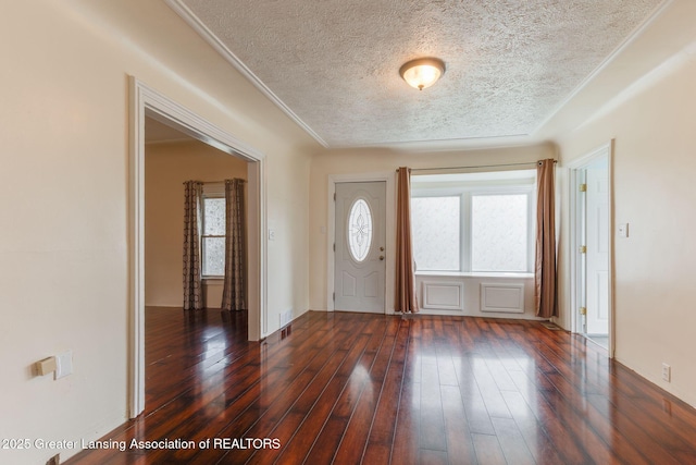 309 W Plain St, Eaton Rapids, MI 48827 - entryway featuring healthy amount of natural light, a textured ceiling, dark wood-style floors, and crown molding