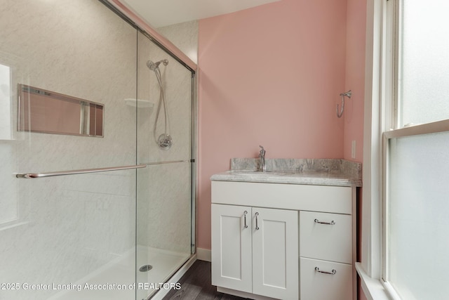 309 W Plain St, Eaton Rapids, MI 48827 - bathroom with a shower stall, vanity, and wood finished floors