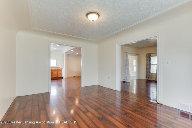 309 W Plain St, Eaton Rapids, MI 48827 - spare room featuring a textured ceiling, wood-type flooring, plenty of natural light, and crown molding