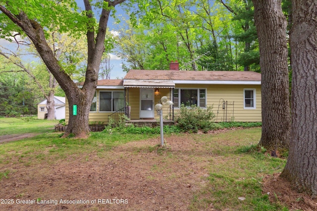 3105 Allen Ln, Harrison, MI 48625 - ranch-style house with a chimney, covered porch, and a front yard