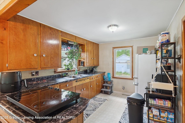 3105 Allen Ln, Harrison, MI 48625 - kitchen with a sink, freestanding refrigerator, black electric stovetop, brown cabinets, and light floors