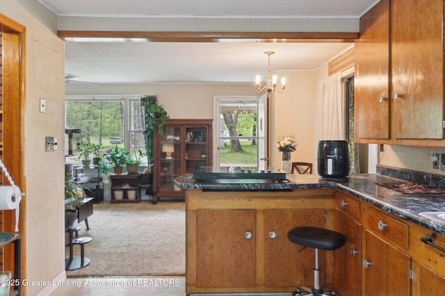 3105 Allen Ln, Harrison, MI 48625 - kitchen with light carpet, brown cabinetry, a peninsula, dark countertops, and healthy amount of natural light