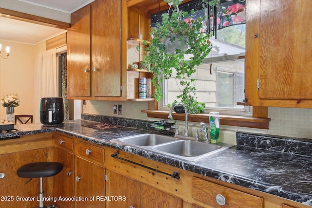 3105 Allen Ln, Harrison, MI 48625 - kitchen featuring a sink, decorative backsplash, plenty of natural light, brown cabinetry, and crown molding