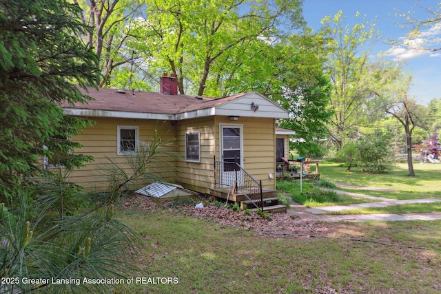 3105 Allen Ln, Harrison, MI 48625 - rear view of house with a chimney and a lawn