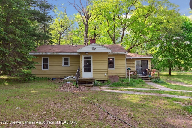 3105 Allen Ln, Harrison, MI 48625 - rear view of property featuring a yard, a chimney, and a wooden deck