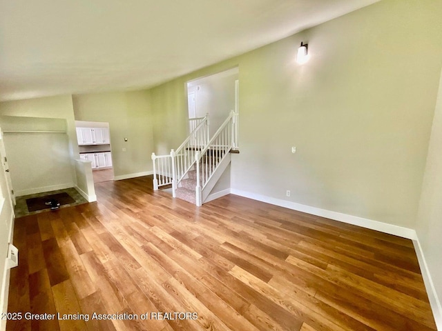 4408 Arbor Dr, Okemos, MI 48864 - spare room featuring wood finished floors, baseboards, and stairs