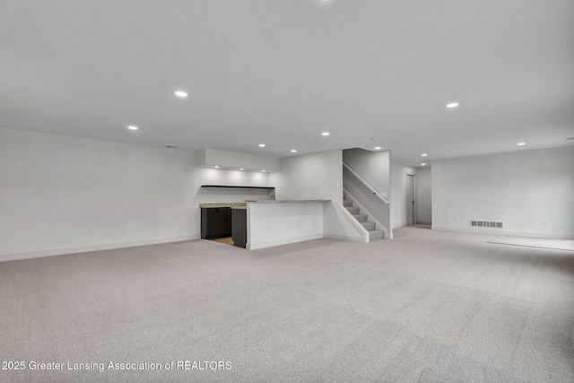 3115 Dietz Rd, Williamston, MI 48895 - unfurnished living room featuring recessed lighting, stairs, light carpet, and baseboards