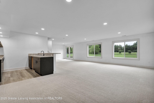 3115 Dietz Rd, Williamston, MI 48895 - unfurnished living room featuring recessed lighting, a sink, light wood-type flooring, and baseboards