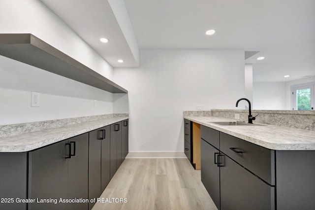 3115 Dietz Rd, Williamston, MI 48895 - kitchen with a sink, light wood-type flooring, light countertops, recessed lighting, and baseboards