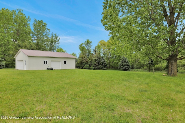 3115 Dietz Rd, Williamston, MI 48895 - view of grassy yard with a detached garage and an outbuilding