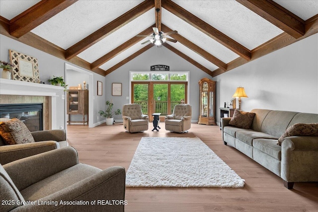 4582 N Watson Rd, Elsie, MI 48831 - living area featuring beamed ceiling, a tiled fireplace, high vaulted ceiling, ceiling fan, and baseboards