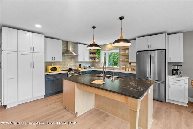4582 N Watson Rd, Elsie, MI 48831 - kitchen with high quality appliances, wall chimney exhaust hood, a sink, light wood finished floors, and recessed lighting