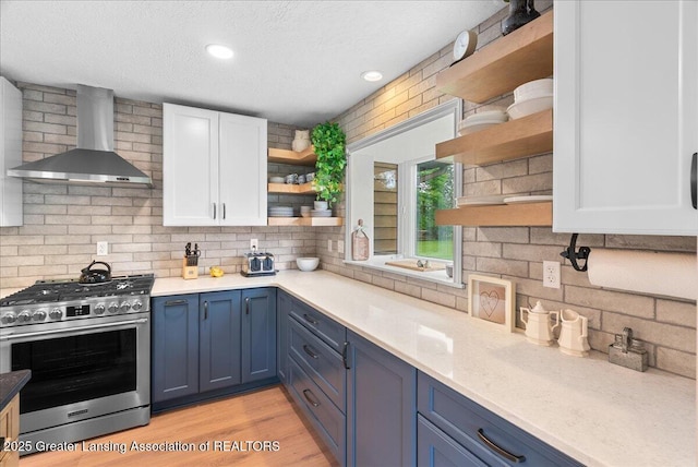 4582 N Watson Rd, Elsie, MI 48831 - kitchen with open shelves, stainless steel gas range, wall chimney range hood, white cabinetry, and blue cabinets